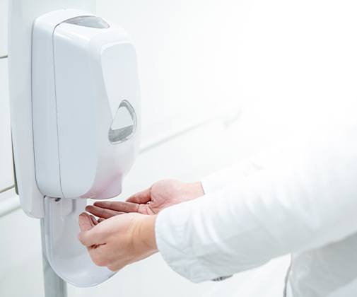 Dentist using chemical disinfectant on hands