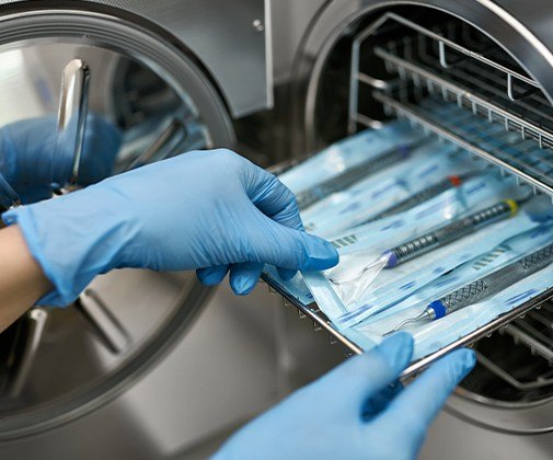 Team member sterilizing dental equipment