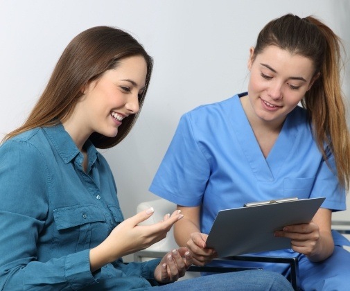 Dental team member reviewing pre and postoperative care instructions with wisdom tooth patient